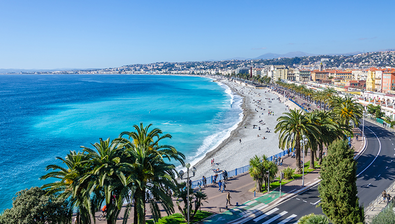 La promenade des anglais à nice- une place avec des palmiers, la mer méditérannée bleu azur et la promenade qui court le long de la plage